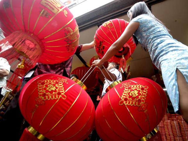 A saleswoman holds Chinese lanterns for a customer in front of a department store on the eve of Chinese New Year at Manila's Chinatown district of Binondo in the Philippines. (AP photo) A saleswoman holds Chinese lanterns for a customer in front of a department store on the eve of Chinese New Year at Manila's Chinatown district of Binondo in the Philippines. (AP photo)