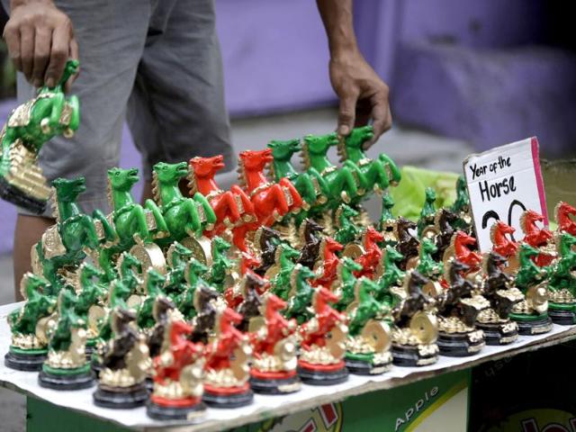 A vendor arranges wooden horse which he sells for about 50 cents on the eve of Chinese New Year at Manila's Chinatown district of Binondo in the Philippines. (AP photo) A vendor arranges wooden horse which he sells for about 50 cents on the eve of Chinese New Year at Manila's Chinatown district of Binondo in the Philippines. (AP photo)