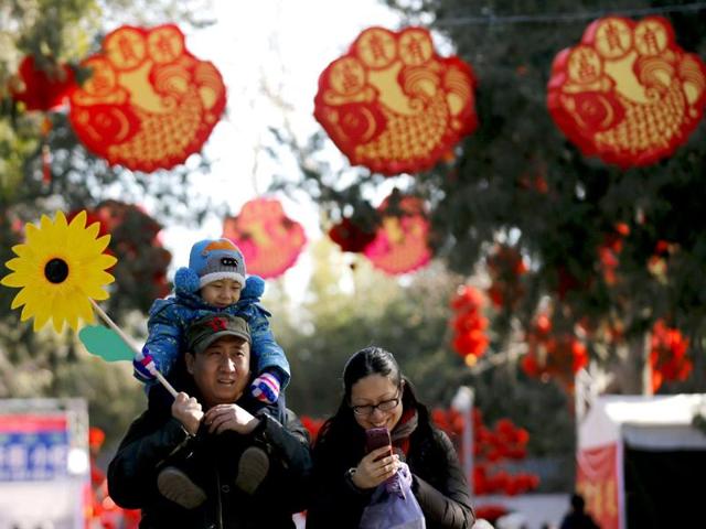 A family walks underneath Chinese New Year decorations during the opening of the temple fair for the Chinese New Year celebrations at Ditan Park, also known as the Temple of Earth, in Beijing. (Reuters photo) A family walks underneath Chinese New Year decorations during the opening of the temple fair for the Chinese New Year celebrations at Ditan Park, also known as the Temple of Earth, in Beijing. (Reuters photo)