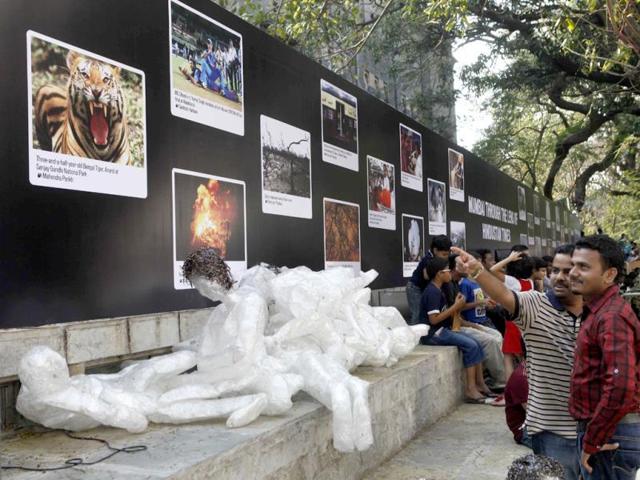 Visitors looking at some photos on display at the Kala Ghoda Arts Festival in Mumbai. (Kalpak Pathak/HT)