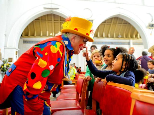 A clown entertains children during the annual service in memory of celebrated clown Joseph Grimaldi, at the Holy Trinity Church, in London. (AP photo)