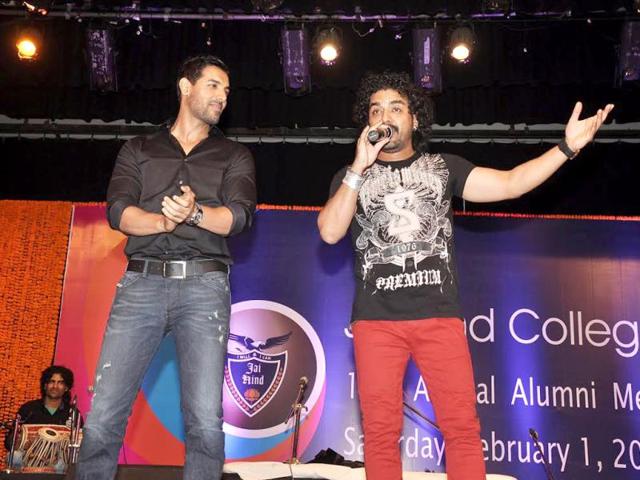 John Abraham looks on as singer Toshi Sabri performs at the meet. 