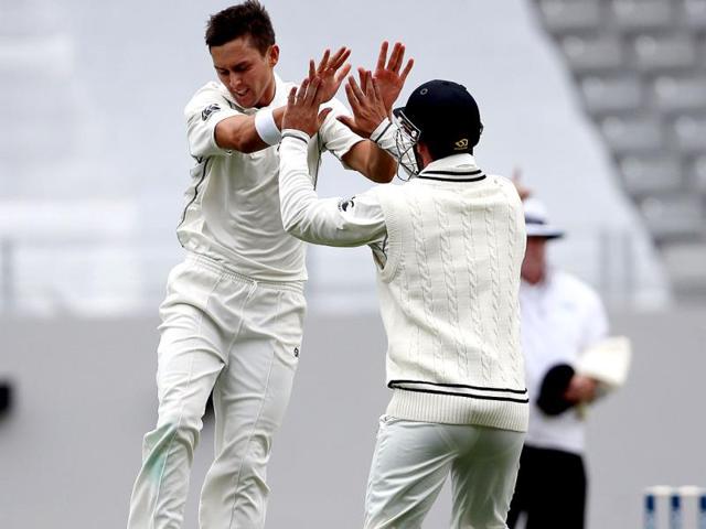 Trent Boult of New Zealand celebrates with Hamish Rutherford (R) the wicket of Cheteshwar Pujara during day two of the first Test at Eden Park in Auckland. (AFP Photo)