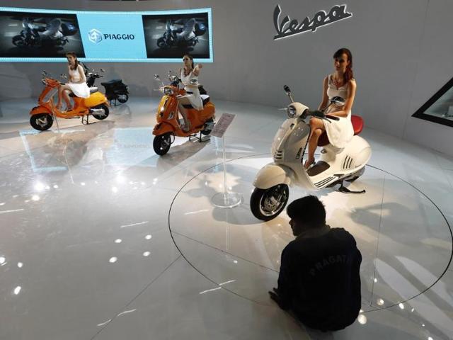 Automotive firms tutor the girls about their company, the vehicles and other details. Models sit on scooters at the Vespa pavilion as a worker cleans the floor during the 12th Auto Expo 2014 in Greater Noida, on the outskirts of New Delhi. (Reuters)