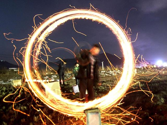 A resident twirls a can with holes filled with burning wood chips and straws to celebrate the first full moon of the Lunar New Year, in Yongin, South Korea on the same day as Valentine's Day (AP photo) A resident twirls a can with holes filled with burning wood chips and straws to celebrate the first full moon of the Lunar New Year, in Yongin, South Korea on the same day as Valentine's Day (AP photo)