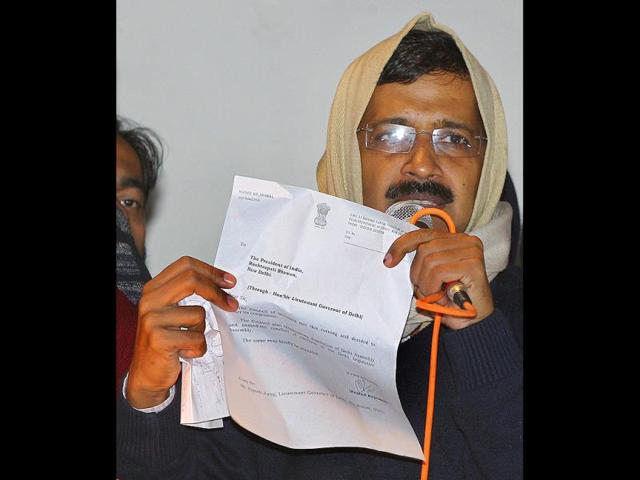Delhi chief minister Arvind Kejriwal shows his resignation letter to Aam Aadmi Party supporters while addressing them at the party office in New Delhi on February 14, 2014. (PTI photo)