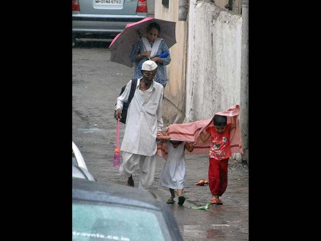 People walk with their children in the unexpected Mumbai rains (Kunal Patil/HT)