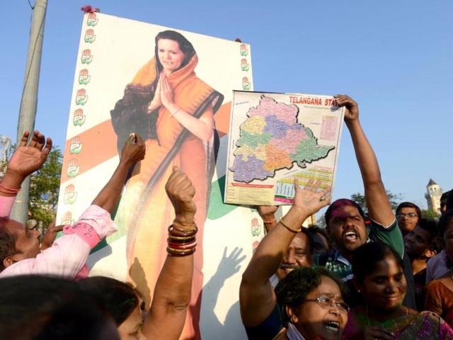 TRS supporters hold a hoarding of Congress president Sonia Gandhi as they celebrate the planned creation of Telangana state in Hyderabad. (AFP photo)