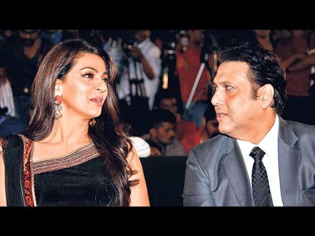 Juhi Chawla and Govinda engrossed in a conversation at an event.