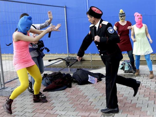 Cossack militia attacked Russia's Pussy Riot punk group with horsewhips as they tried to perform under a sign advertising the Sochi Olympics. (AP photo)