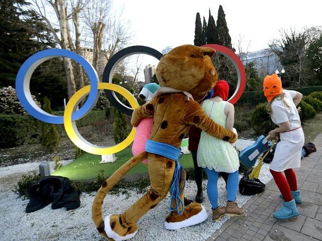 The Sochi mascot accompanies Pussy Riot group after they were attacked to safety (AP photo)
