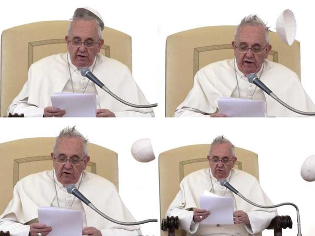 Pope Francis struggles as a gust of wind blows his skull cap off in Saint Peter's Square at the Vatican. (Reuters photo)