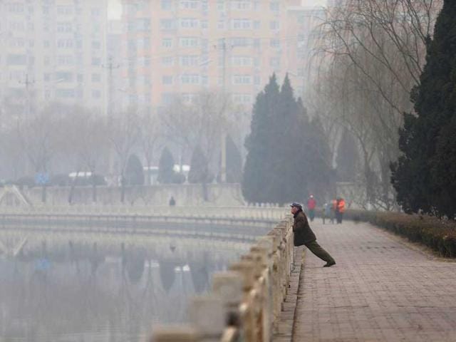 Picture shows a man (R) exercizing in haze-covered Beijing. (AFP photo)