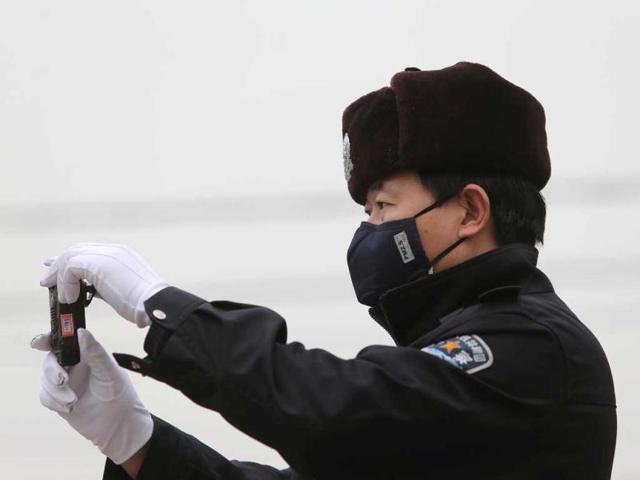 A policeman is seen wearing with a mask in smog-covered Beijing. China's National Meteorological Centre issued a "yellow" smog alert for much of the country's north, the fifth consecutive day of heavy pollution. (AFP photo)