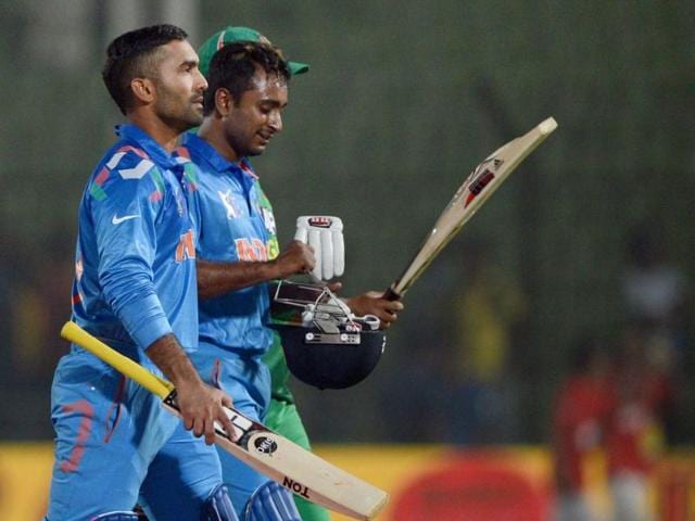Dinesh Karthik (L) and Ambati Rayudu (R) walk off the field after winning the second match of the Asia Cup against Bangladesh at the Khan Shaheb Osman Ali Stadium in Fatullah. (AFP Photo)