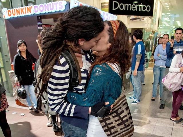 A gay couple kisses during the "Besaton", a "kiss marathon" against discrimination, at a shopping centre in Bogota, Colombia (AFP photo)