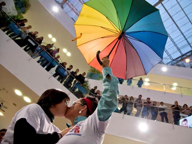 People look at activists demonstration during the "Besaton", a "kiss marathon" against discrimination, at a shopping centre in Bogota, Colombia (AFP photo)