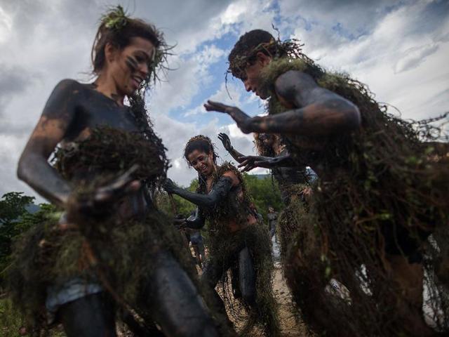 Revelers participate in the traditional 28th Bloco da Lama (Mud block) carnival in Parati, Brazil. The event is a traditional carnival in which participants disguised as primitives with rags, lianas or skulls and bones, dive in the mud (AFP photo)