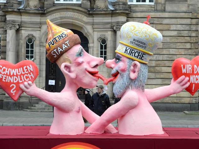 A float featuring Russian President Vladimir Putin (L) kissing Russian Orthodox Church patriarch Kirill with texts reading "Anti Gay?" and "Not us!" makes its way through the streets of Duesseldorf. (AFP Photo)