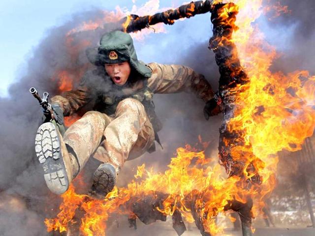 A Chinese frontier soldier from the People's Liberation Army jumps through a ring of fire as part of training in Heihe, Heilongjiang province. (Reuters Photo) A Chinese frontier soldier from the People's Liberation Army jumps through a ring of fire as part of training in Heihe, Heilongjiang province. (Reuters Photo)