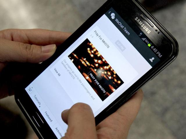 A message 'Pray for MH370' is shown by mobile messaging app WeChat on a smartphone at Kuala Lumpur International Airport in Sepang. (AP Photo)