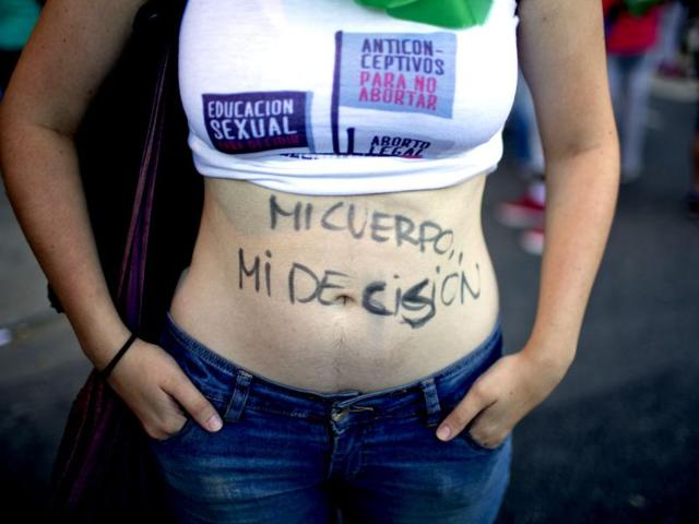A woman stands during a rally with the words written on her body reading in Spanish "My body, my decision" in Buenos Aires, Argentina (AP photo)