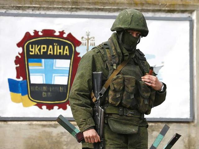 An-armed-man-believed-to-be-a-Russian-serviceman-stands-guard-outside-an-Ukrainian-military-base-in-the-village-of-Perevalnoye-near-the-Crimean-city-of-Simferopol-March-9-2014-Reuters-Photo An-armed-man-believed-to-be-a-Russian-serviceman-stands-guard-outside-an-Ukrainian-military-base-in-the-village-of-Perevalnoye-near-the-Crimean-city-of-Simferopol-March-9-2014-Reuters-Photo