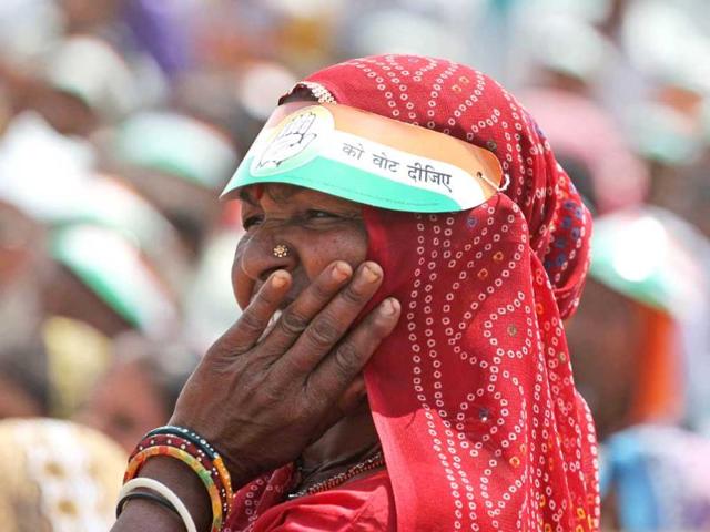 An woman listens to a speech by the country's ruling Congress party vice president Rahul Gandhi during an election rally at Balasinor, Gujarat. (AP Photo)