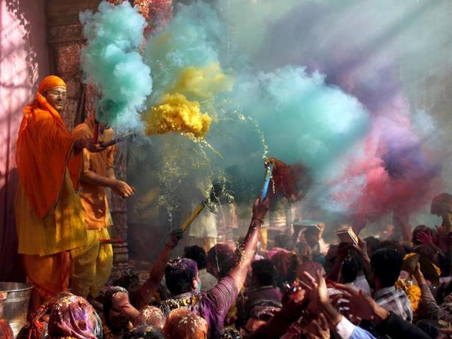 Hindu priests throwing coloured powder at the devotees during Holi celebrations at Bankey Bihari temple in Vrindavan, Uttar Pradesh. (Reuters photo)