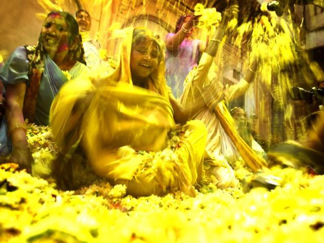 Hindu widows throw flower petals at each other as part of Holi celebrations organized by a non-governmental organization Sulabh at the Meera Sahbhagini Ashram in Vrindavan (Ajay Aggarwal/HT photo)