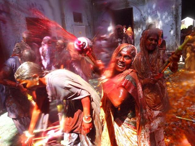 Hindu widows throw colour at each other as part of Holi celebrations organised by a non-governmental organization Sulabh at the Meera Sahbhagini Ashram in Vrindavan. (Ajay Aggarwal/HT Photo)