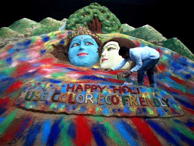 Indian sand artist Sudarsan Patnaik gives a final touch to a sand sculpture of the Hindu god Lord Radha Krishna ahead of the forthcoming spring festival Holi in Bhubaneswar. (AFP photo)