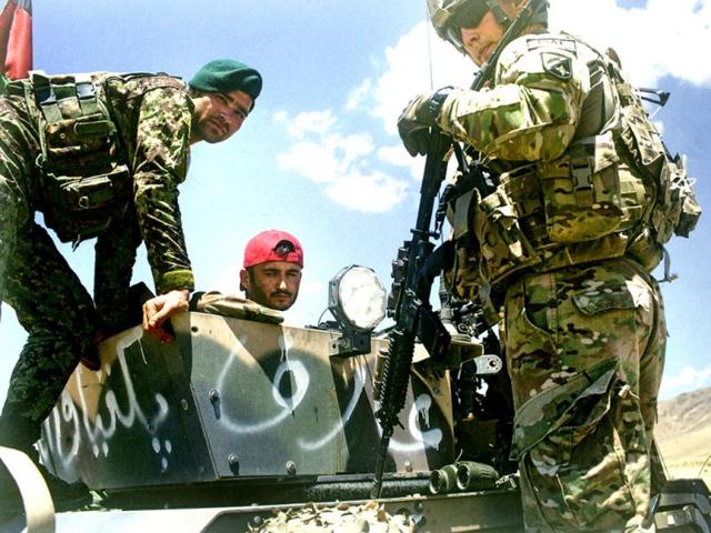 May 2013: A US army officer from the 3rd Infantry Division examines why a weapon misfired. American and Nato soldiers serve as advisors as Afghan troops take primary responsibility in military operation. (Robert Nickelsberg)