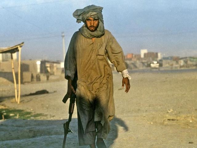 May 1997: A Taliban soldier walks away from where his comrade was shot down in Mazar-i-Sharif. (Robert Nickelsberg)