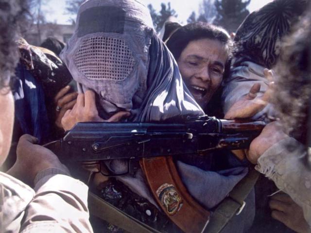 March 1993: Armed guards prevent women from gaining access to United nations supplies of flour in Kabul during a food shortage. (Robert Nickelsberg)