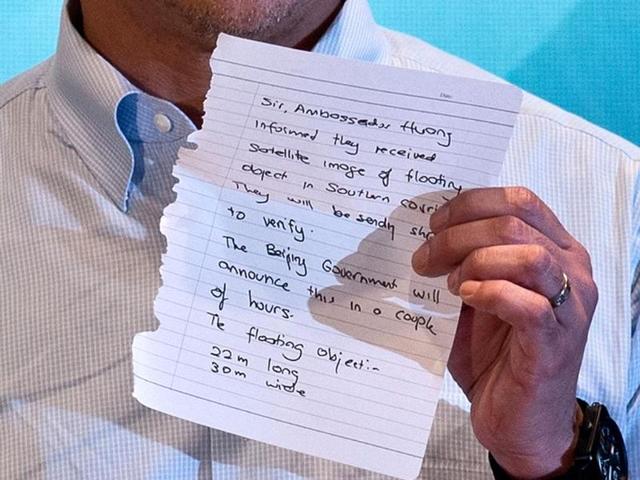Malaysian transport minister Hishammuddin Hussein shows a note from the Chinese ambassador stating that they have received new satellite images during the search for missing Malaysia Airlines (MAS) flight MH370, at a press conference near Kuala Lumpur International Airport in Sepang. (AFP PHOTO)