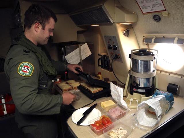 Sergeant Samuel Carson prepares meals for crew aboard a Royal Australian Air Force (RAAF) AP-3C Orion, as they search for missing Malaysian Airlines flight MH370 in the southern Indian Ocean. (Reuters)