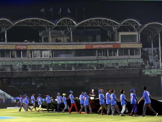Groundsmen cover the pitch to protect it from rain during the ICC World Twenty20 match between England and New Zealand in Chittagong, Bangladesh. (AP Photo)