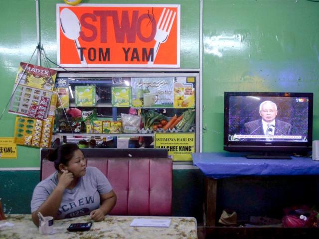Malaysia's prime minister Najib Razak is seen on television, making an announcement on the latest development on the missing Malaysia Airlines MH370 plane at Putra World Trade Center, at a coffee shop in Shah Alam in Kuala Lumpur. (Reuters)