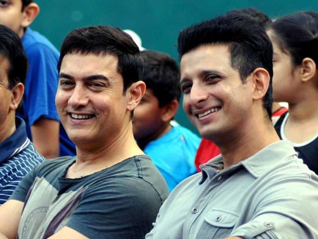 Aamir Khan and Sharman Joshi look on during the All India Open Women's Tennis Tournament 2014 finals in Mumbai on late March 23, 2014. (AFP)
