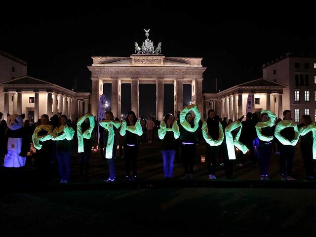 Activists of the World Wide Fund For Nature (WWF) spell out the words Earth Hour 2014 in front of the illuminated Brandenburg gate before the lights were turned off to mark Earth Hour in Berlin. (AP photo)