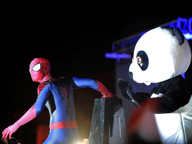 A performer dressed as Spiderman and the WWF panda mascot prepare to turn off the lights from a floating platform for Earth Hour in Singapore. (AFP photo)