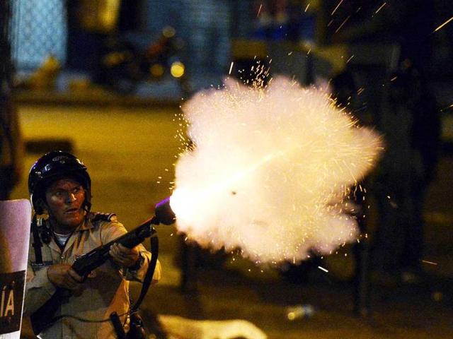 A National Guard member shoots during anti-government protests, in Caracas. (AFP Photo) 
