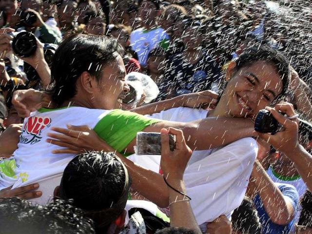 A Balinese girl (R) tries to avoid a kiss from another during the "Omed Omedan" kissing festival in Bali, Indonesia. (AP Photo) 