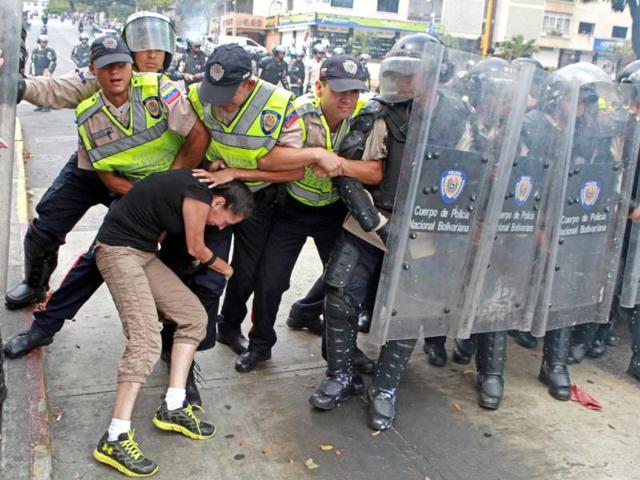 An anti-government activist clashes with riot police during a protest in Caracas. (AFP Photo)