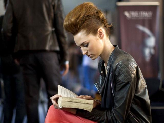A model reads a book backstage before modeling the Alexia Ulibarri collection at Mexican Fashion Week in Mexico City. (AP)