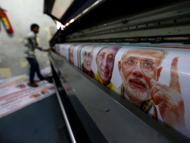 A worker operates a machine to print banners of Narendra Modi, BJP's prime ministerial candidate ahead of the general elections in Ghaziabad. (Reuters Photo)