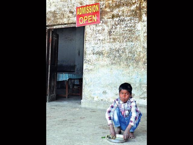 A-student-eats-his-mid-day-meal-while-an-admission-open-board-hangs-above-Kuldeep-Rana-HT-Photo A-student-eats-his-mid-day-meal-while-an-admission-open-board-hangs-above-Kuldeep-Rana-HT-Photo