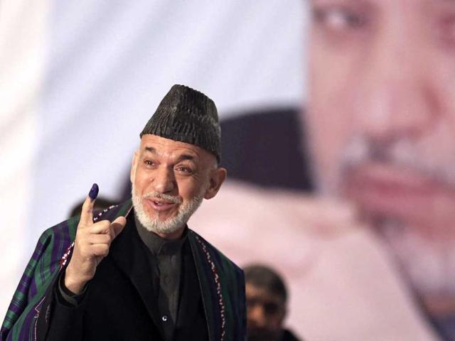 Afghan President Hamid Karzai shows indelible ink on his finger to the media before he casts his vote at Amani High School, near the presidential palace in Kabul. (AP Photo)