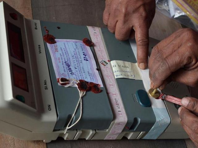 Election Commission officials seal an Electronic Voting Machine (EVM) prior to the start of voting at a polling station in Dibrugarh, Assam. (AFP photo)